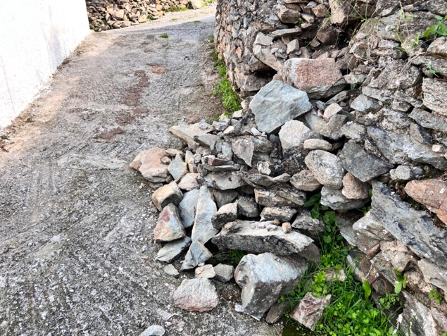 A pile of rocks next to a wall

Description automatically generated